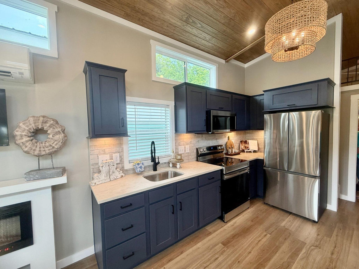 Honey Hollow kitchen with navy cabinets, stainless refrigerator, and electric fireplace