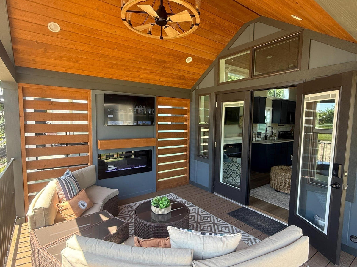 Covered porch at Honey Hollow with outdoor seating, TV, and fireplace